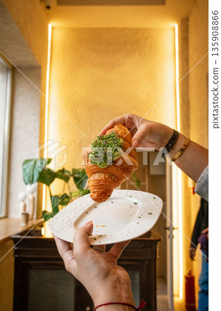 Croissant with pistachio cream being served 135908866