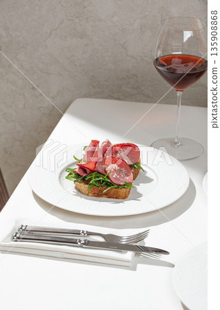 Toast with cured beef and fresh greens 135908868