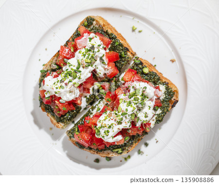 Bruschetta with pesto tomatoes and burrata Bruschetta with pesto tomatoes and burrata 135908886