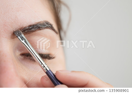 Caucasian woman getting eyebrow tinting procedure.  135908901