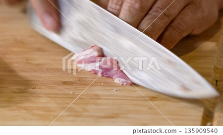 Close up of chef Butcher cutting pork meat with knife on kitchen, cooking food. The chef butcher preparing pork meat for cooking. Close up of chef Butcher cutting pork meat with knife on kitchen, cooking food. The chef butcher preparing pork meat for cooking. 135909540