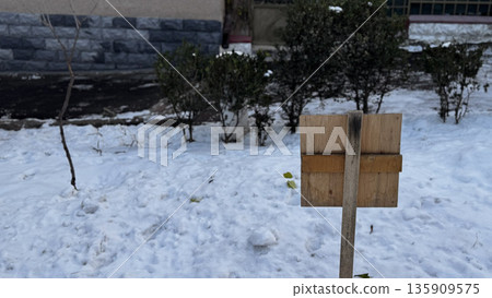 Winter Landscape with Wooden Sign in Snowy Setting 135909575