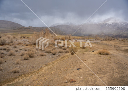 Gravel road through deserted valley leading from Mars Altai Russia. Remote pathway to famous colorful geological landmark. Gravel road through deserted valley leading from Mars Altai Russia. Remote pathway to famous colorful geological landmark. 135909608
