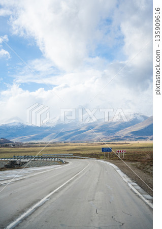 Mountain road and valley of Chuysky Trakt Altai Russia. Scenic route through rugged terrain and expansive natural landscape Mountain road and valley of Chuysky Trakt Altai Russia. Scenic route through rugged terrain and expansive natural landscape 135909616