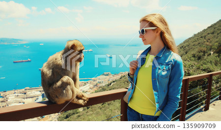 Woman tourist and macaque monkey. Gibraltar Woman tourist and macaque monkey. Gibraltar 135909709