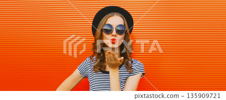 Portrait of beautiful young woman blowing her lips sending sweet air kiss Portrait of beautiful young woman blowing her lips sending sweet air kiss 135909721