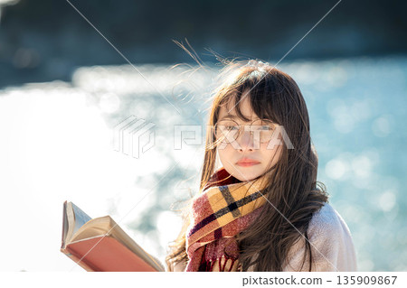 A woman reading a book by the beach A woman reading a book by the beach 135909867