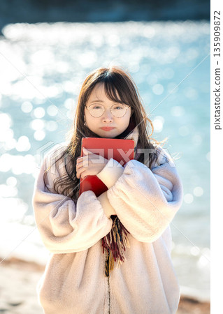 A woman reading a book by the beach A woman reading a book by the beach 135909872