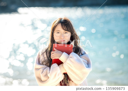 A woman reading a book by the beach A woman reading a book by the beach 135909873