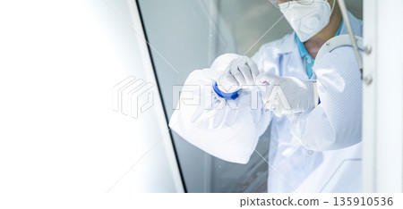 Hands of medical personnel holding a nasal swab ATK is collecting germs from a negative pressure operating room to determine whether or not we have coronavirus. Hands of medical personnel holding a nasal swab ATK is collecting germs from a negative pressure operating room to determine whether or not we have coronavirus. 135910536