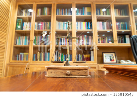 Golden Scale in vintage mood and tone lays on wooden table in front of wood library in Asia. Golden Scale in vintage mood and tone lays on wooden table in front of wood library in Asia. 135910543