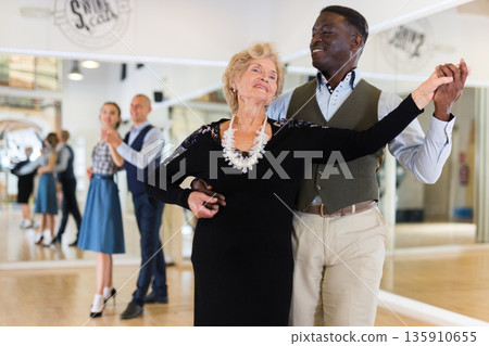 Man and mature woman learning to dance classical ballroom dance 135910655