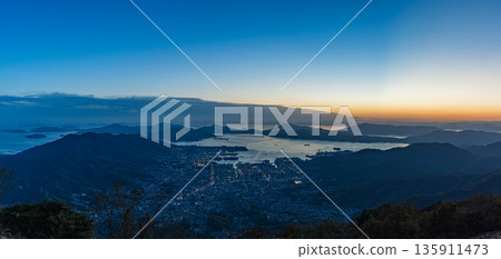 View of Kure city and the Seto Inland Sea at dusk from the Haigamine observation deck in Tochihara-cho, Kure City, Hiroshima Prefecture, Japan View of Kure city and the Seto Inland Sea at dusk from the Haigamine observation deck in Tochihara-cho, Kure City, Hiroshima Prefecture, Japan 135911473