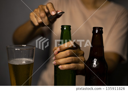 Woman Opening Beer Bottle With Opener, A lively ad photo of woman opening beer bottle with opener, cap popping in crisp light, perfect for casual drink campaign or refreshing moment documentary. 135911826