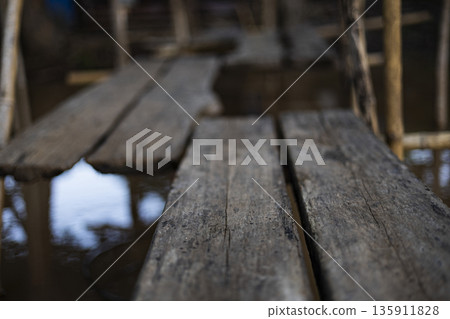 Wooden Path Above Rainy Flood, A tense ad photo of wooden path above rainy flood, planks slick with water in stormy light, perfect for adventure gear campaign or resilient escape documentary. 135911828