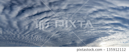 Patches of altocumulus clouds spreading across the early morning blue sky 135912112