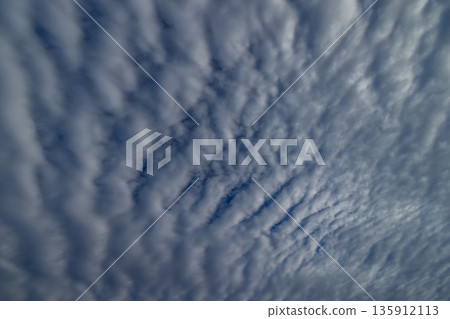 Patches of altocumulus clouds spreading across the early morning blue sky 135912113