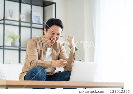 Middle man using a computer in the living room 135912235