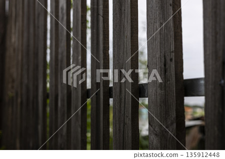 Wooden Sun Blocking Fence Wall, A sturdy documentary shot of sun shield wooden fence, light filtering through slats in golden hour, ideal for home improvement or textured shade showcase. Wooden Sun Blocking Fence Wall, A sturdy documentary shot of sun shield wooden fence, light filtering through slats in golden hour, ideal for home improvement or textured shade showcase. 135912448