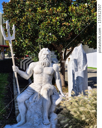 Neptune or Poseidon sculpture holding a trident. 135912507
