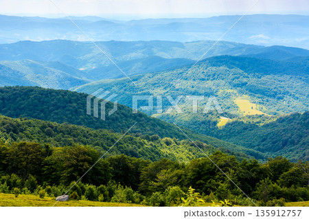 mountain landscape with rolling hills. summer countryside scenery of ukraine with view in to the distant valley and green forested slopes on a sunny forenoon. background for hiking and eco tourism mountain landscape with rolling hills. summer countryside scenery of ukraine with view in to the distant valley and green forested slopes on a sunny forenoon. background for hiking and eco tourism 135912757