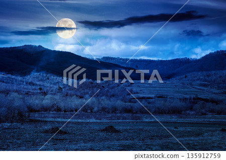 early spring rural landscape in carpathian mountains at night. beautiful view of countryside scenery with field in march in full moon light. backdrop for fiction art or mystery concepts early spring rural landscape in carpathian mountains at night. beautiful view of countryside scenery with field in march in full moon light. backdrop for fiction art or mystery concepts 135912759