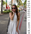 Stylish woman walking on Beverly Hills street in white dress 135912914