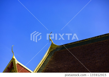 Traditional Thai Roof Against Clear Sky, View of the blue sky and the roof church at Buddhist temple in Thailand. Roof Of Thai Temple With Blue Sky And Cloud. 135912915
