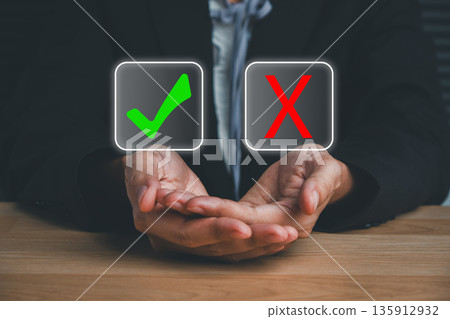 Hands presenting check mark and cross icons, symbolizing decision-making and evaluation in business contexts. 135912932