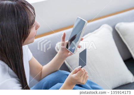Young woman with smartphone and credit card Young woman with smartphone and credit card 135914173