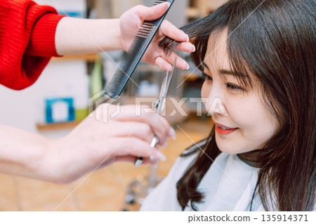 Woman cutting hair in hair salon Woman cutting hair in hair salon 135914371