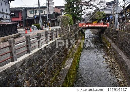 日本岐阜縣高山市的古老街景。古老的房屋散發著歷史氣息。高山春季祭典期間的清晨景象。一條小溪穿過城市。 135914387