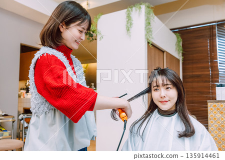 A young woman getting her hair done at a beauty salon 135914461