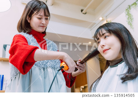 A young woman getting her hair done at a beauty salon 135914505