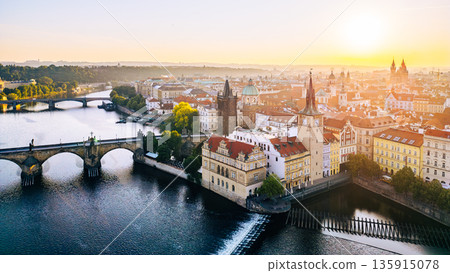 Charles Bridge stands majestically over the Vltava River, connecting the Old Town and Lesser Town. The warm glow of sunrise highlights the intricate details of the Old Town Bridge Tower. Charles Bridge stands majestically over the Vltava River, connecting the Old Town and Lesser Town. The warm glow of sunrise highlights the intricate details of the Old Town Bridge Tower. 135915078