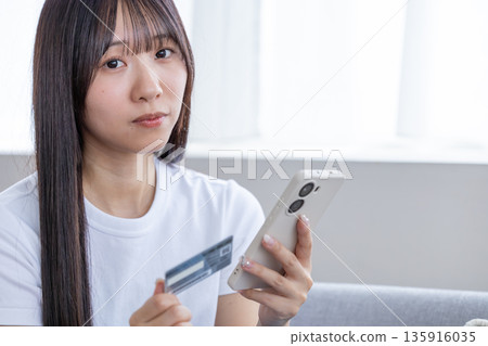 Young woman with smartphone and credit card Young woman with smartphone and credit card 135916035