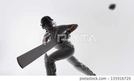 Cricket player defending ball with bat during match action. Cricket player defending ball with bat during match action. 135916720