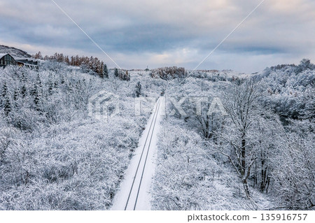 Hakodate Main Line in winter: A local train running straight across the snowy plains 135916757