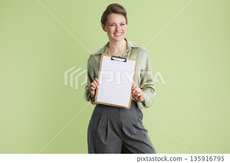 Smiling professional woman with a blank clipboard Smiling professional woman with a blank clipboard 135916795