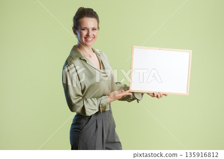Smiling woman presenting white sign Smiling woman presenting white sign 135916812