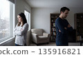 Stressed couple avoids eye contact indoors. Couple conflict in modern living room, couple thinking about divorce, for marriage counseling promo or mental health awareness concept today 135916821