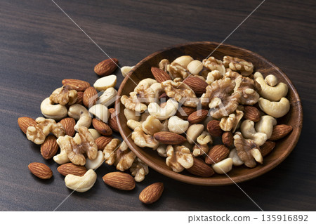 Mixed nuts in a wooden bowl Mixed nuts in a wooden bowl 135916892