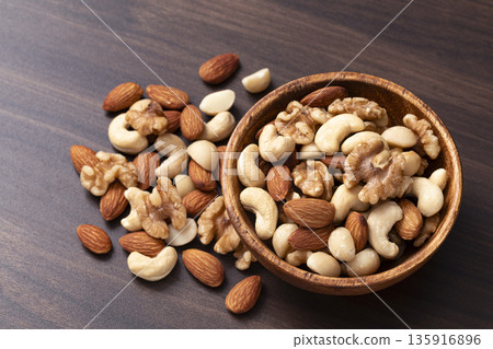 Mixed nuts in a wooden bowl Mixed nuts in a wooden bowl 135916896