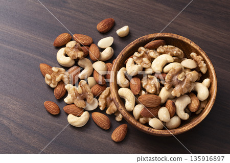 Mixed nuts in a wooden bowl Mixed nuts in a wooden bowl 135916897