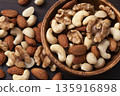 Mixed nuts in a wooden bowl Mixed nuts in a wooden bowl 135916898