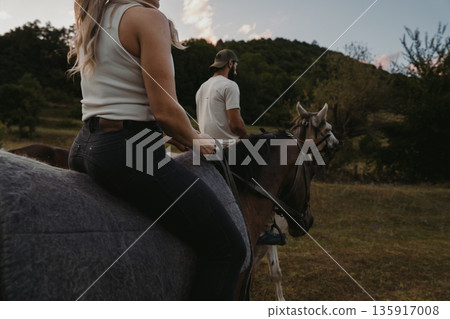 Riding horses at sunset near a forest in the countryside with friends 135917008
