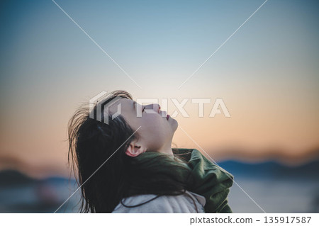 Evening sea and sky and young woman Evening sea and sky and young woman 135917587