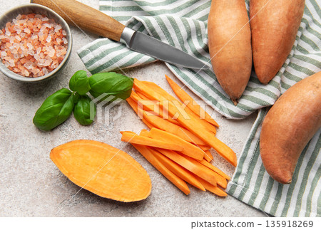 Preparing sweet potato fries with salt, basil, and a knife 135918269