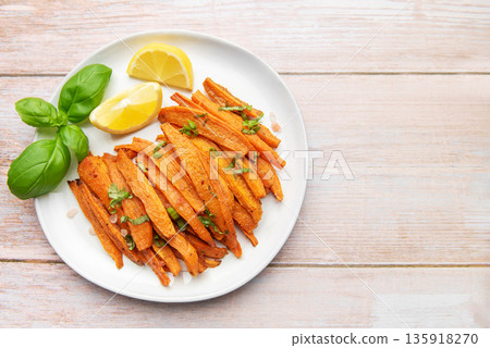Roasted sweet potato fries with basil and lemon 135918270