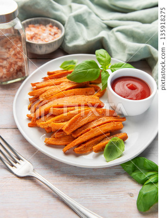 Sweet potato fries with ketchup and fresh basil leaves Sweet potato fries with ketchup and fresh basil leaves 135918275